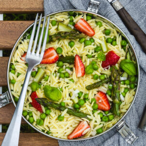 Pasta salad with fresh asparagus, peas and strawberries